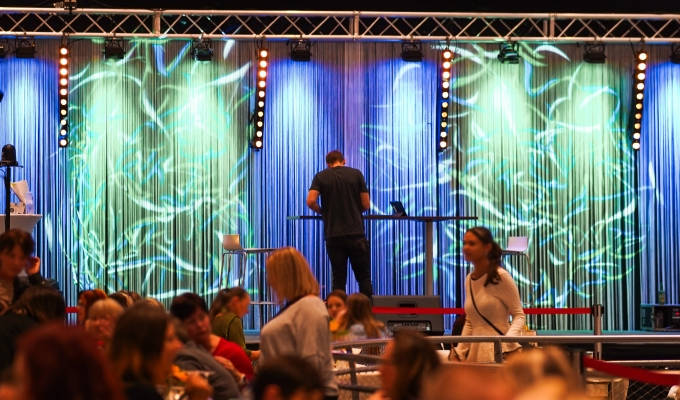 Live quiz on the big stage: host up front, teams at their tables